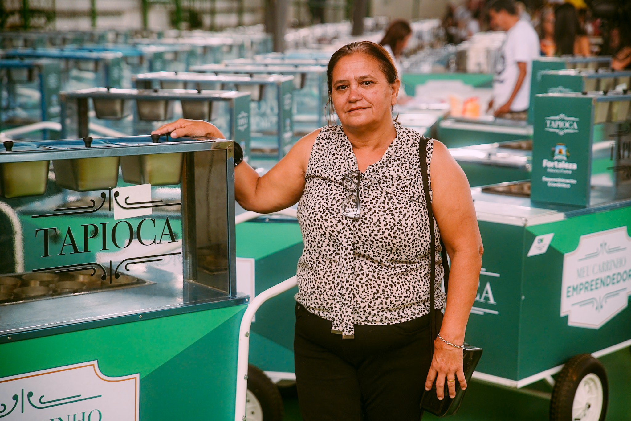 Dona Valdenora posa ao lado do seu carrinho de tapioca